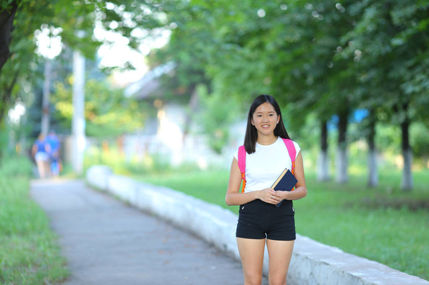Νεαρή κοπέλα περπάτημα στο πάρκο με τα πόδια και βηματισμός - Φωτογραφία, εικόνα