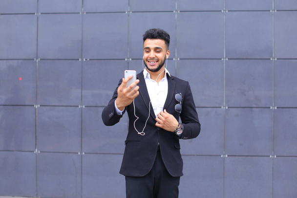 Handsome arabic man takes selfie smart phone in business center - Photo, Image