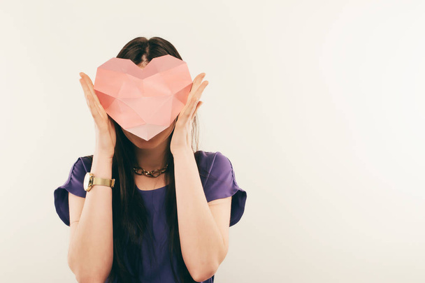 Portrait of young woman in glasses with a heart in his hands. Love - 写真・画像