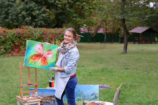 Kunstenaar vrouw houdt van schilderen en kijkt, die zich voordeed op de camera een - Foto, afbeelding