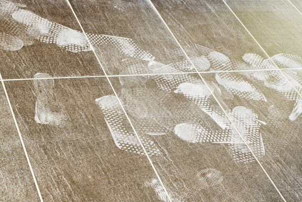 Huellas de los pies en el suelo de baldosas
 - Foto, imagen