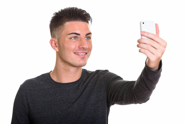 Joven hombre feliz sonriendo tomando selfie con teléfono móvil
 - Foto, imagen