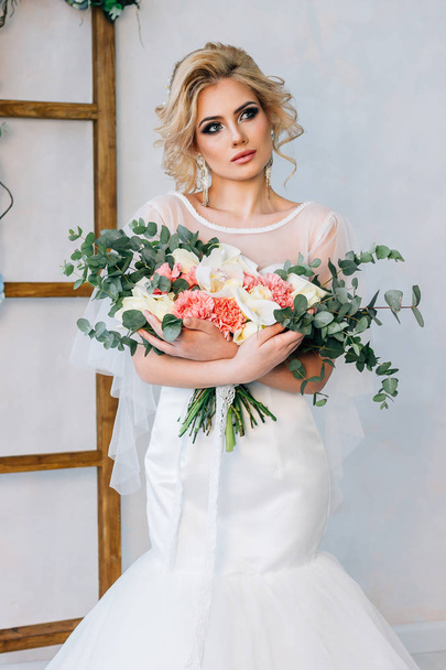 donna in un abito da sposa abbraccia il bouquet
 - Foto, immagini