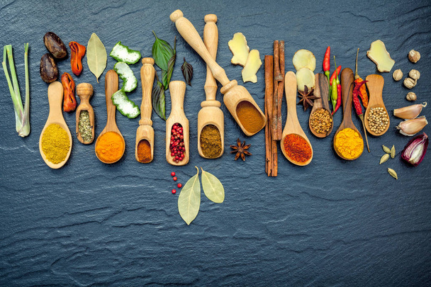 Verschillende kruiden en specerijen in houten lepels. Plat leggen van specerijen - Foto, afbeelding