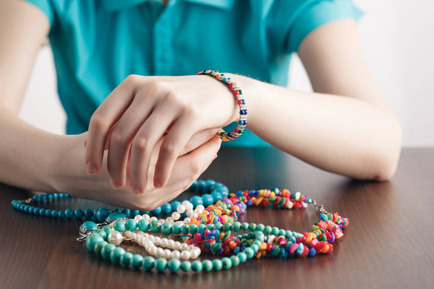 Girl puts bracelet on his hand and a bunch of jewelry - Foto, Imagem