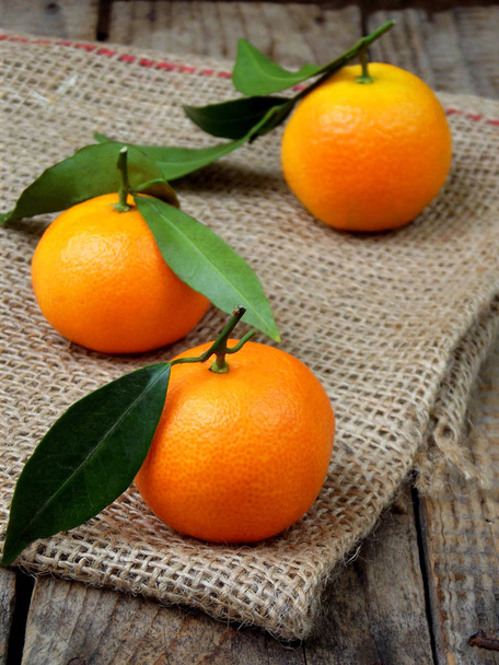 trois mandarines mûres sur fond de bois. focus sélectif
. - Photo, image