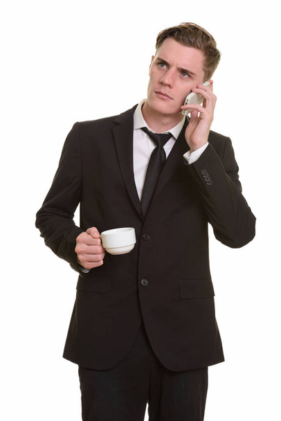 Young handsome Caucasian businessman talking on phone while hold - Photo, Image