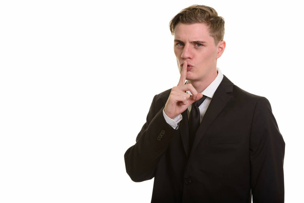 Young handsome Caucasian businessman with finger on lips - Photo, Image