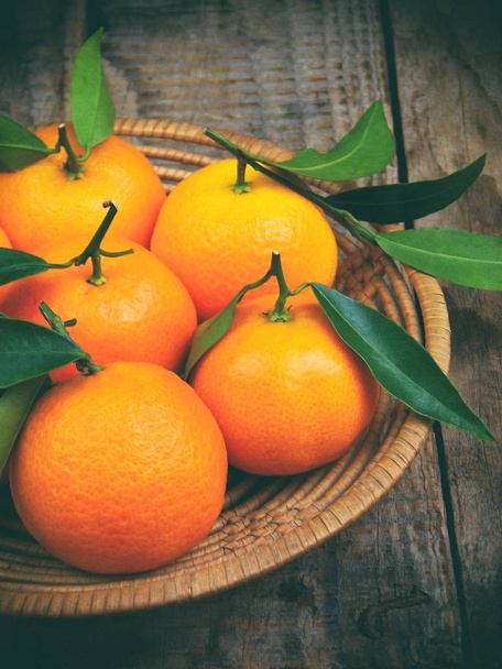 Mandarines mûres dans le panier sur fond bois. focus sélectif
. - Photo, image