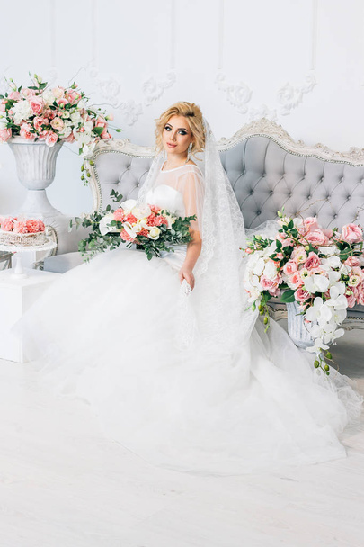 Portrait d'une belle fille dans une robe de mariée entourée de fleurs
 - Photo, image