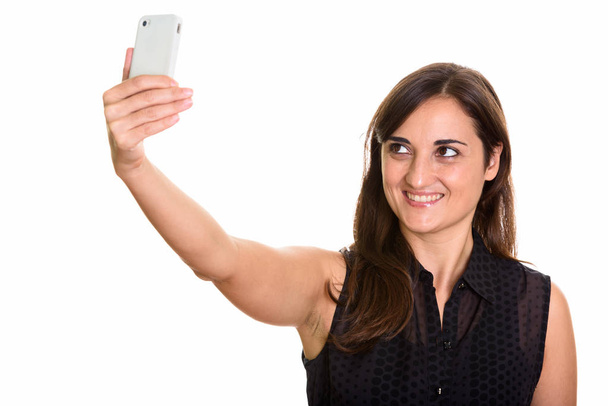 Strzał studio szczęśliwy piękna kobieta uśmiechając się podczas robienia selfie - Zdjęcie, obraz