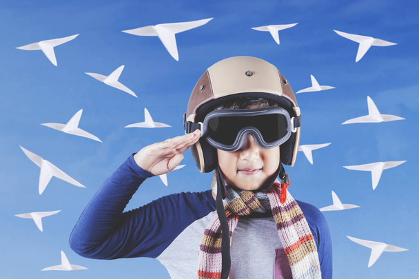 Pequeño aviador con casco y aviones de papel
 - Foto, imagen