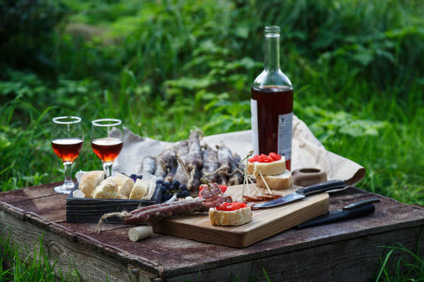 Сосиски, помидоры, хлеб и бокалы красного вина, контрастное вино
. - Фото, изображение