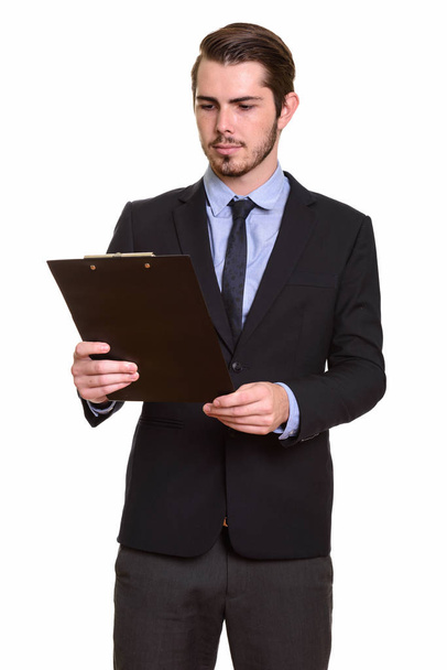 Young handsome Caucasian businessman reading clipboard - Foto, afbeelding