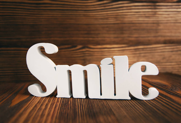 Lächeln Buchstaben auf Holz Hintergrund. - Foto, Bild