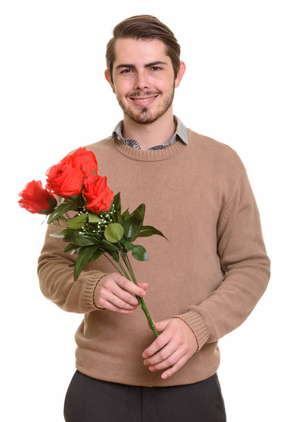 Joven hombre caucásico feliz sosteniendo rosas rojas listo para Valentín '
 - Foto, imagen
