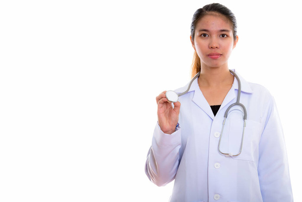 Studio shot of young Asian woman doctor holding stethoscope - Photo, Image