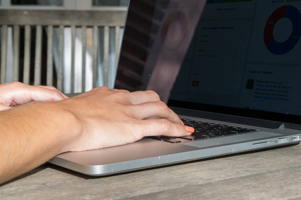 Las manos de la mujer utilizando el ordenador portátil con gráfico analítico en el escritorio en el jardín, el trabajo en el aire libre, freelancer
 - Foto, Imagen