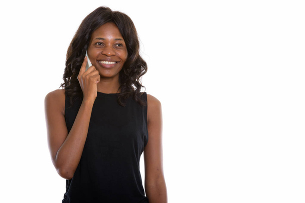 Studioaufnahme einer jungen, glücklichen Schwarzafrikanerin, die lächelt, während sie - Foto, Bild