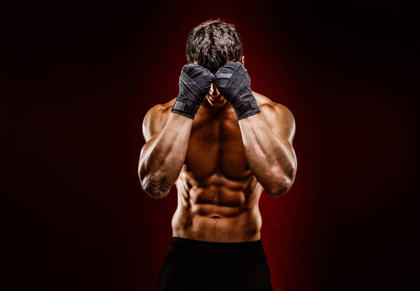 Strong muscular fighter hiding face from camera - Foto, afbeelding