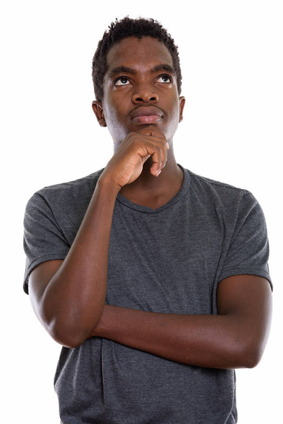 Studio shot de jeune noir africain adolescent garçon penser tandis que lo
 - Photo, image