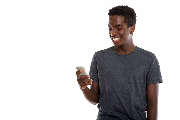 Студийный снимок молодого чернокожего африканского мальчика-подростка, улыбающегося
 - Фото, изображение