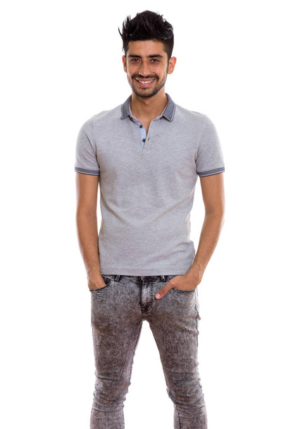 Studio shot of young happy Persian man smiling and standing - Photo, Image
