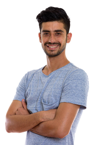 Studio shot de jeune homme persan heureux souriant avec les bras croisés - Photo, image