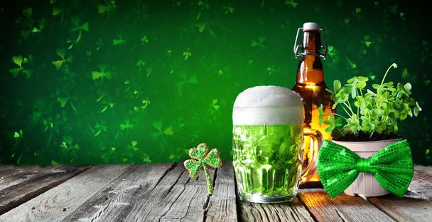 Den svatého Patrika - zelené pivo ve skle s lahví a Čtyřlístek na dřevěný stůl - Fotografie, Obrázek
