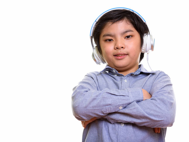 Happy Japanese boy smiling while listening to music with arms cr - 写真・画像