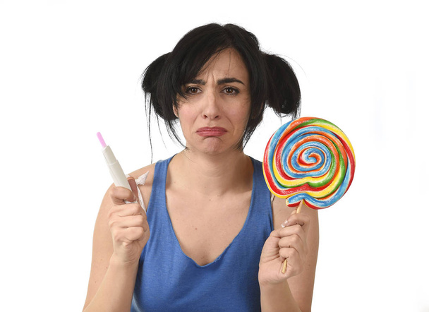 pregnant teenager holding big lollipop while checking positive pink result on pregnancy test  - Photo, Image