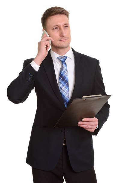 Komea valkoihoinen liikemies puhuu matkapuhelimella, kun hol
 - Valokuva, kuva