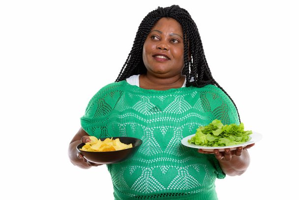 Thoughtful happy fat black African woman smiling while holding b - Valokuva, kuva