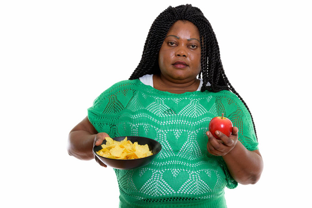 Studio shot of fat black African woman holding bowl of potato ch - Valokuva, kuva