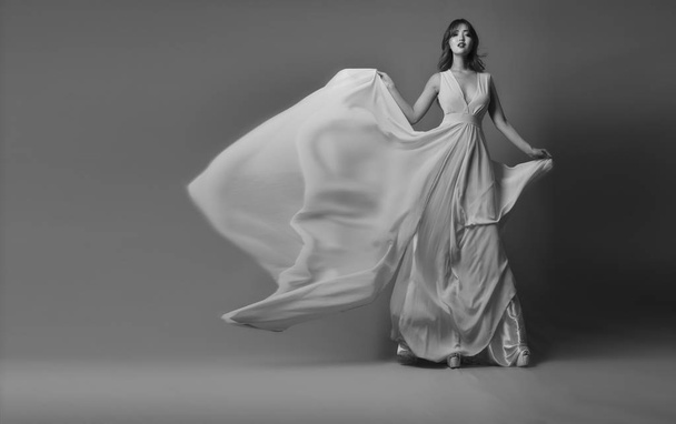 Jonge Aziatische model poseren in elegante lange jurk wapperen in de wind - Foto, afbeelding