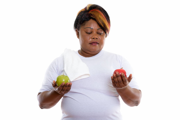 Studio shot of fat black African woman holding green apple and l - Foto, Imagen