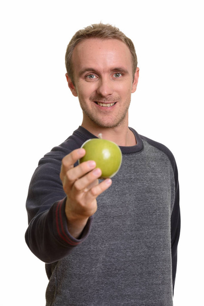 Onnellinen komea valkoihoinen mies antaa vihreä omena - Valokuva, kuva