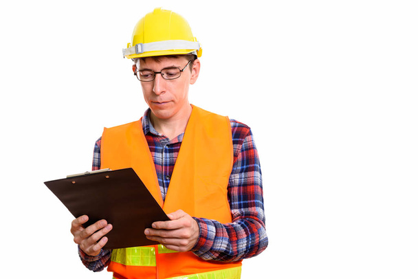 Estudio plano de hombre trabajador de la construcción leyendo en portapapeles - Foto, imagen