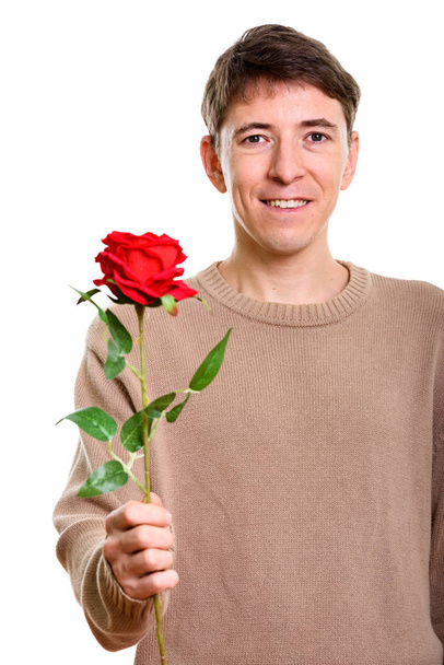 Strzał studio szczęśliwy człowiek uśmiechający się trzymając red rose - Zdjęcie, obraz