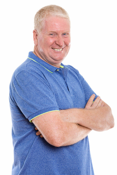 Studio shot of happy mature man smiling with arms crossed  - Photo, Image