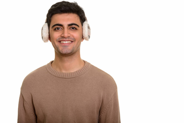 Joven hombre persa feliz con orejeras de invierno - Foto, Imagen