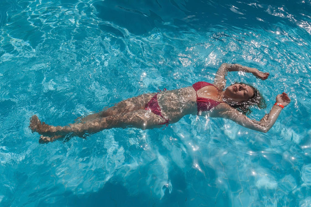 όμορφη γυναίκα που επιπλέει σε μια πισίνα - Φωτογραφία, εικόνα
