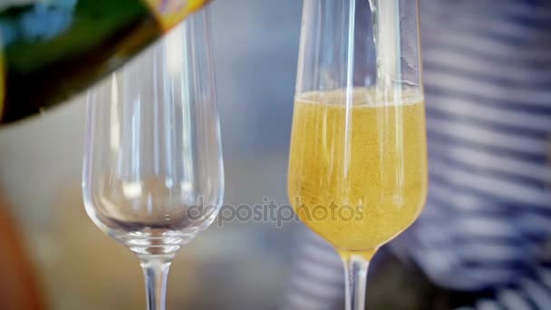Mann gießt Champagner in Gläser. Flasche füllt Weinglas mit Sekt in Zeitlupe. Makroaufnahme. - Filmmaterial, Video