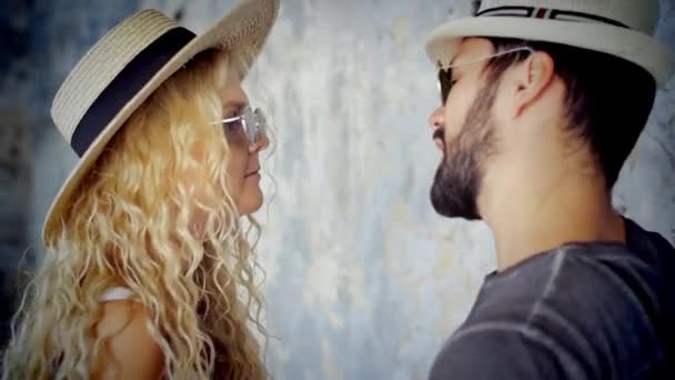 Heureux jeune couple en lunettes de soleil et chapeaux dansant au ralenti en écoutant de la musique s'amuser en amour
. - Séquence, vidéo