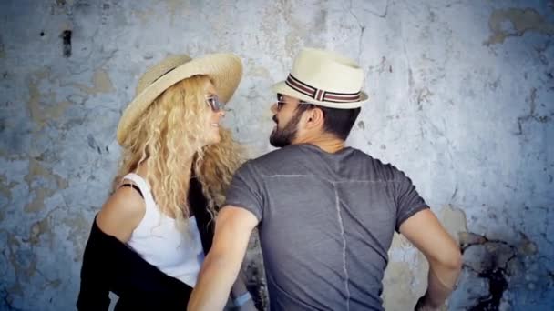 Щаслива молода пара в сонцезахисних окулярах і капелюхах танцює в повільному русі слухаючи музику, розважаючись в любові
. - Кадри, відео