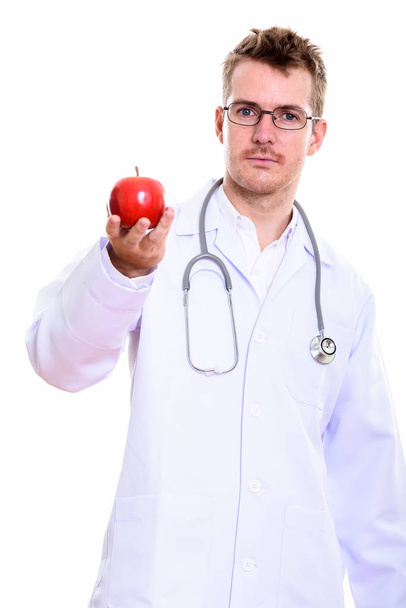 Студийный снимок мужчины-врача с красным яблоком в руках - Фото, изображение
