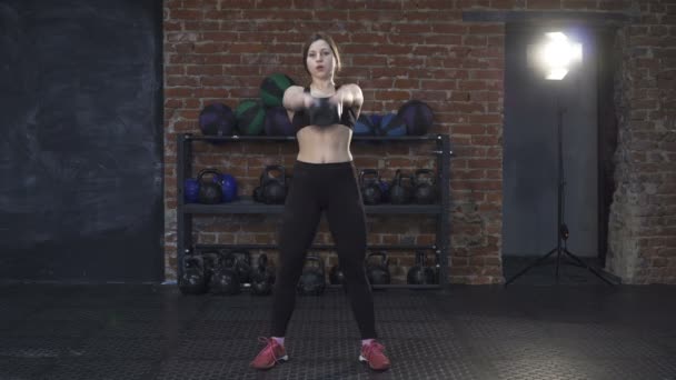 Fitness kobieta robi huśtawki kettlebell - Materiał filmowy, wideo