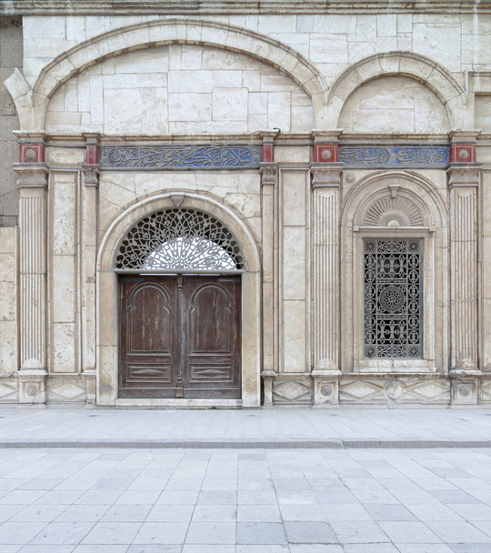 Украшенные окна и деревянные украшенные двери над белой мраморной стены
 - Фото, изображение