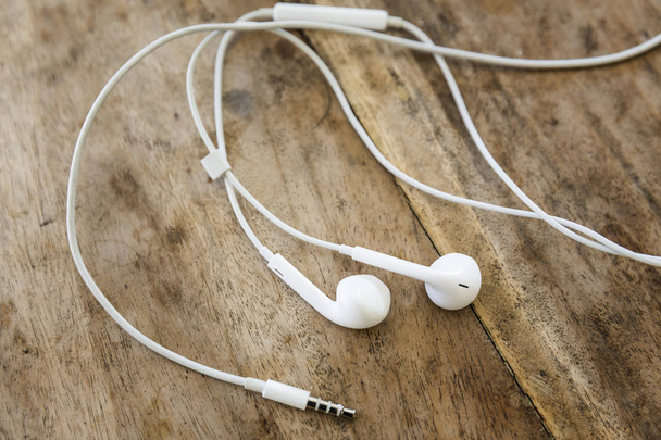 white earphones on wooden background - Fotografie, Obrázek