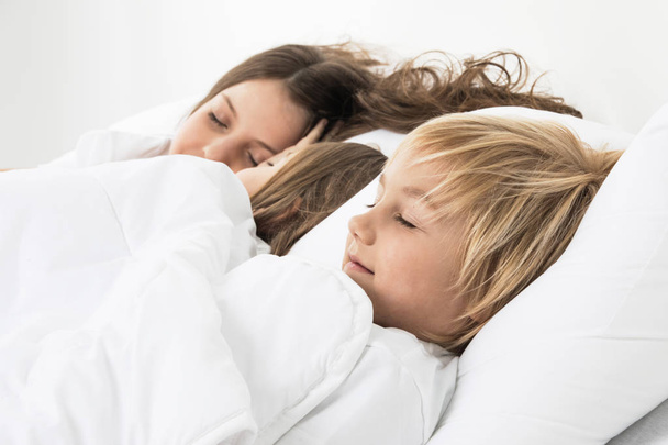 Three children sleeping in bed - Фото, изображение